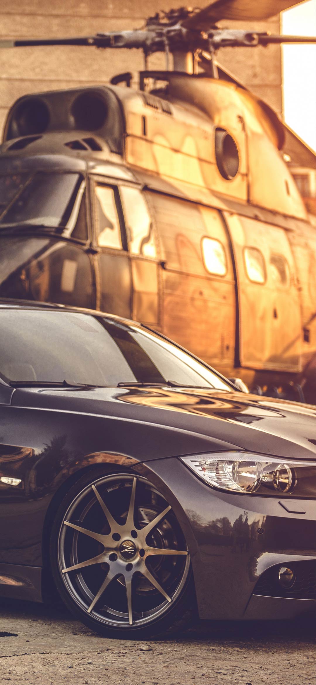 سيارة BMW سوداء اللون تقف بجانب مروحية خلفيات