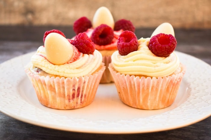 Easter vegan cupcakes on a plate next to daffodils