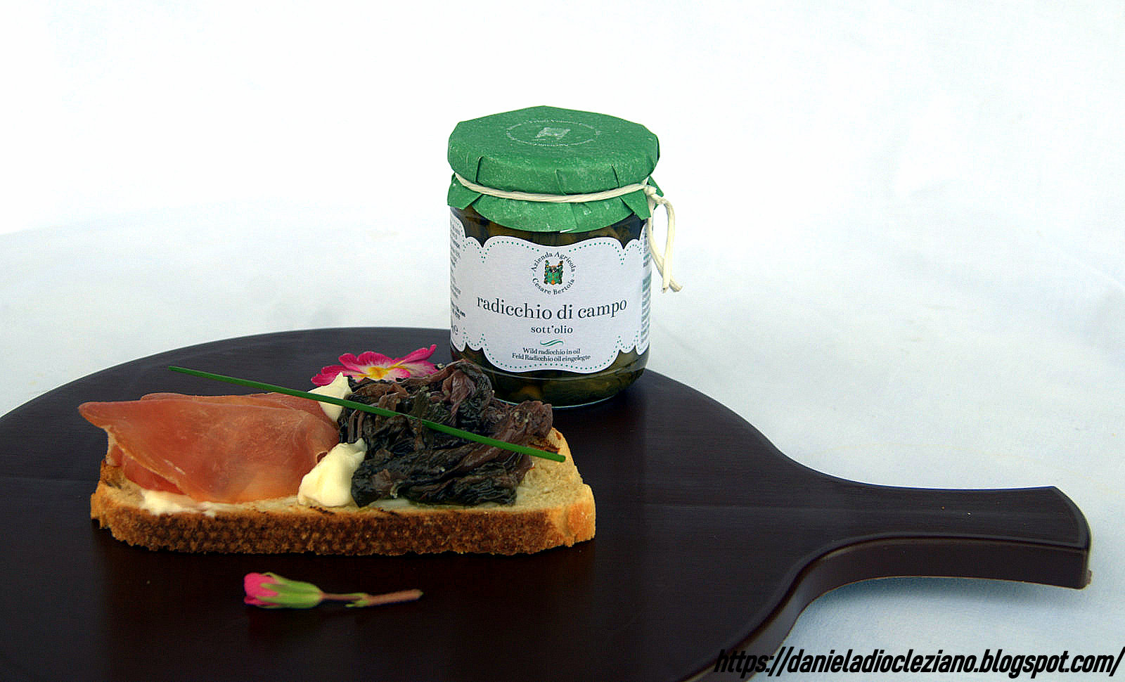 Bruschetta con caprino , radicchio di campo sott'olio e prosciutto