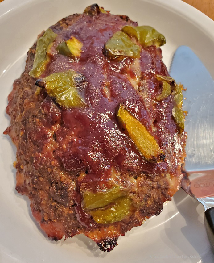 this is a barbecue sauce topped venison meatloaf baked with peppers on top