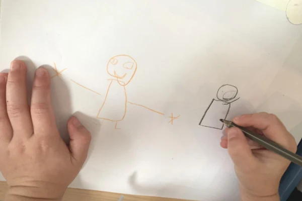 child drawing people with black skin and white skin