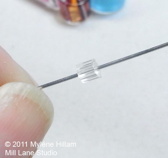 String an earring stopper onto a head pin to use inside large hole beads