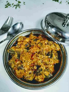 Serving bhindi (okra) masala in a serving bowl with spoon and fork in background