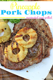 Marinated and grilled pork chops on white platter with sliced pineapples grilled