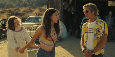 Once Upon a Time in Hollywood 2019 movie still where Lena Dunham and Margaret Qualley hold hands while talking to Brad Pitt