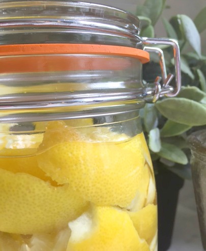 Lemon peels marinating in vodka for a limoncello recipe shared here by Hello Lovely Studio.