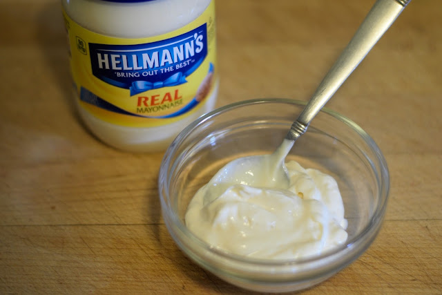 The Hellmann's mayonnaise in a bowl with a spoon. 