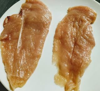 Two slice of a chicken breast for chicken fingers recipe