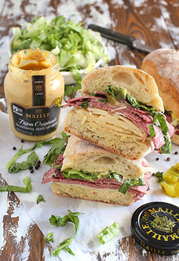 Loaded-Pastrami-and-Swiss-Sandwich-1 Recipe for an over-stuffed sandwich filled with pastrami, Swiss cheese, shredded lettuce, diced pickles, mayo and mustard on toasted Ciabatta rolls.