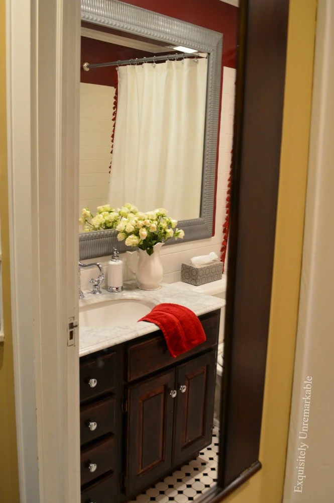 Cottage Style Bathroom with dark vanity, white marble top and black and white checkered flooring