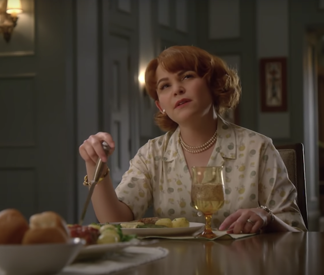 Ginnifer Goodwin in Why Women Kill. Ginnifer is sitting at the dinner table and has a thoughtful expression on her face.