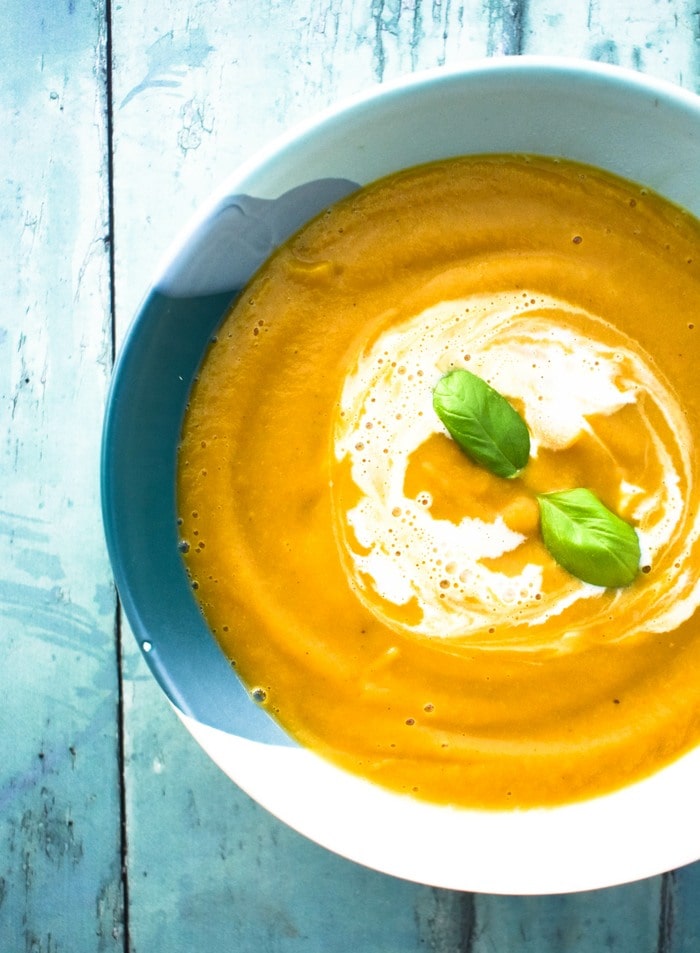 A bowl of smooth butternut squash soup with a swirl of cream