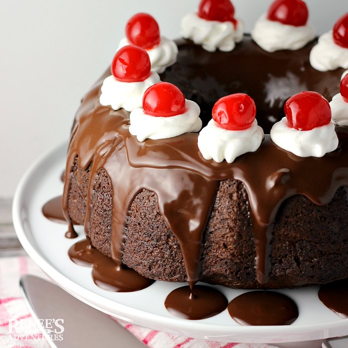 Chocolate Cherry Cake by Renee's Kitchen Adventures whole bundt cake decorated with whipped topping and maraschino cherries