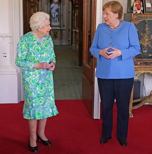 Queen Elizabeth wore a blue and green floral dress with an diamond Cambridge Emerald Cluster Brooch. Anello and Davide of Kensington shoes