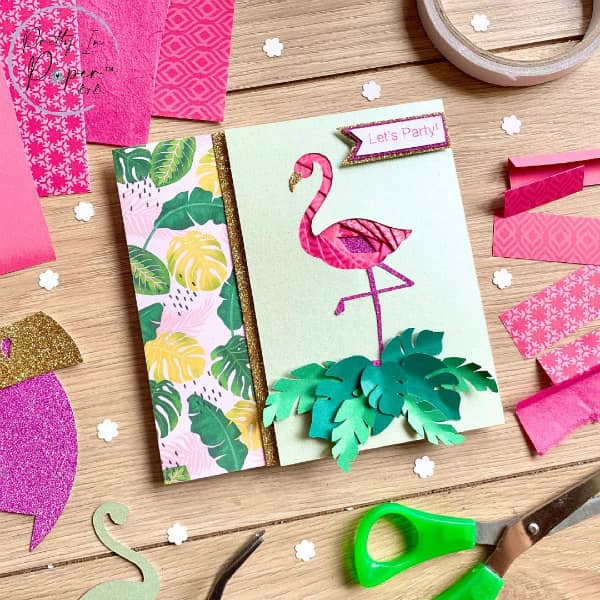 iris gevouwen flamingo-kaart omringd door knutselspullen voor papier