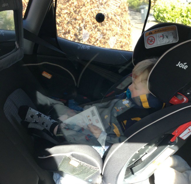picture with reflections of a toddler asleep in a car seat