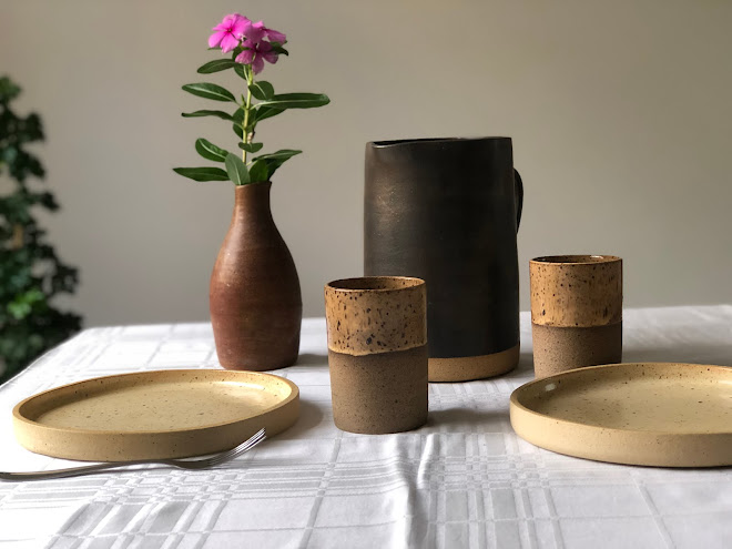 Mesa com pratos, copos e jarra de cerâmica