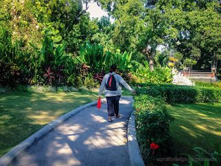 Woman Traveler Walking On The Walkway Of Beautiful Garden In Warmth Of The Morning Sunshine At Tangguwisia Village North Bali Indonesia