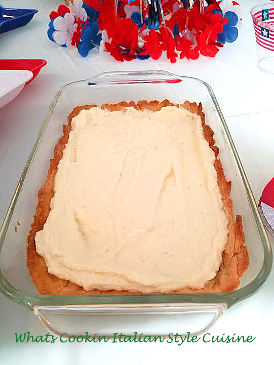 This is a flag shaped cheese pie in a rectangular glass pan with whipped cream, blueberries, sliced strawberries and baked pie crust to make this creative pattern for the 4th of July