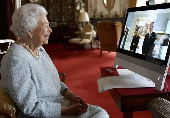 Queen Elizabeth wore a sky blue dress and gold diamond brooch, pearl necklace