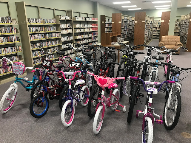 Bicycles available for checkout at New Albany library A collection of about twenty bicycles sits in the middle of a library.