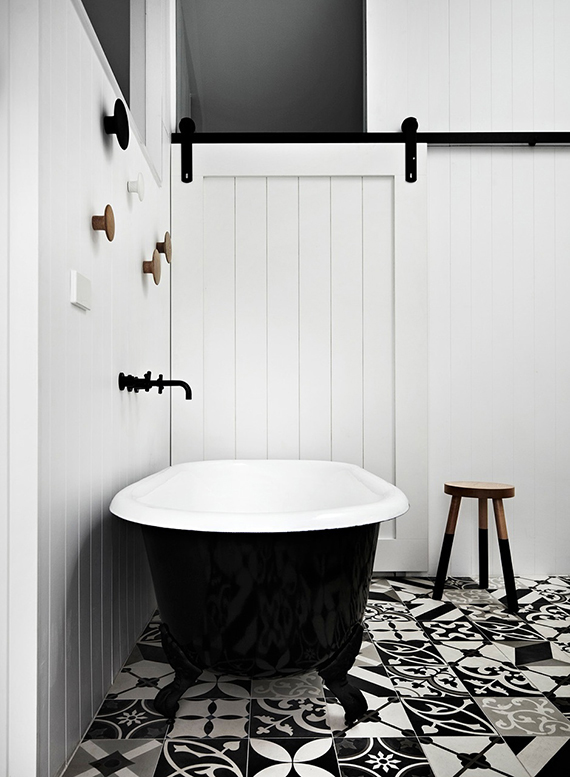 Black fixtures in the bathroom | B&w cement floor tiles and a black bathtub in this bathroom designed by Whiting Architects.