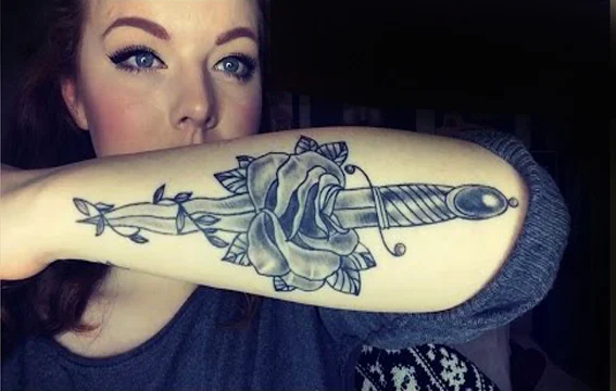 vemos a una mujer joven con tatuaje de cuchillo o tatuaje de daga