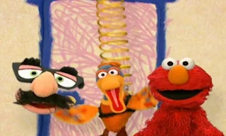 Elmo and Groucho Marx Glasses play a game. when Elmo says the secret word, a duck springs down from the ceiling and bounces in on a spring. Elmo's World Eyes Interview