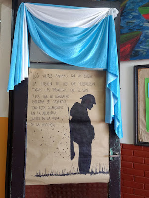 cartelera escolar con la imagen de la silueta de un soldado argentino