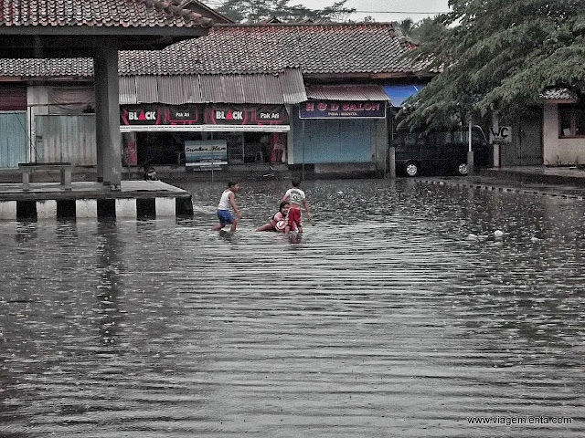 Crianças brincam na cidade inundada após a chuva