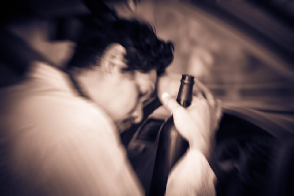 Man behind the wheel with a beer bottle in hand