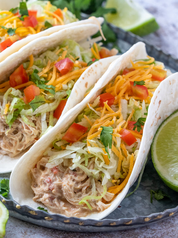 This easy crock pot taco recipe is unique, flavorful, uses pantry and fridge ingredients and is such an inexpensive meal. Use this slow cooked creamy shredded chicken for burritos, tacos, tostadas, taco salad, enchiladas, taquitos and more!