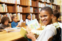 elementary students reading at a table in the library