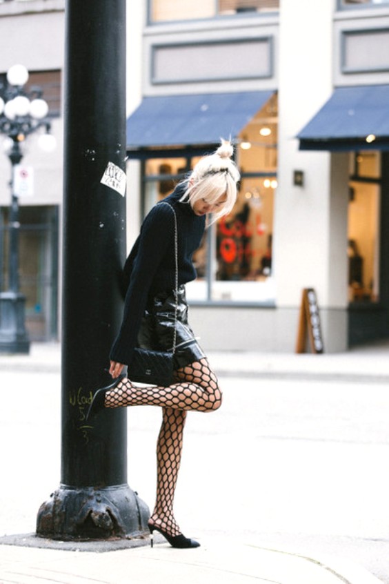 Woman wearing black fishhnet tights and black mules