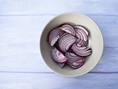 red onion a small white bowl full of sliced red onion