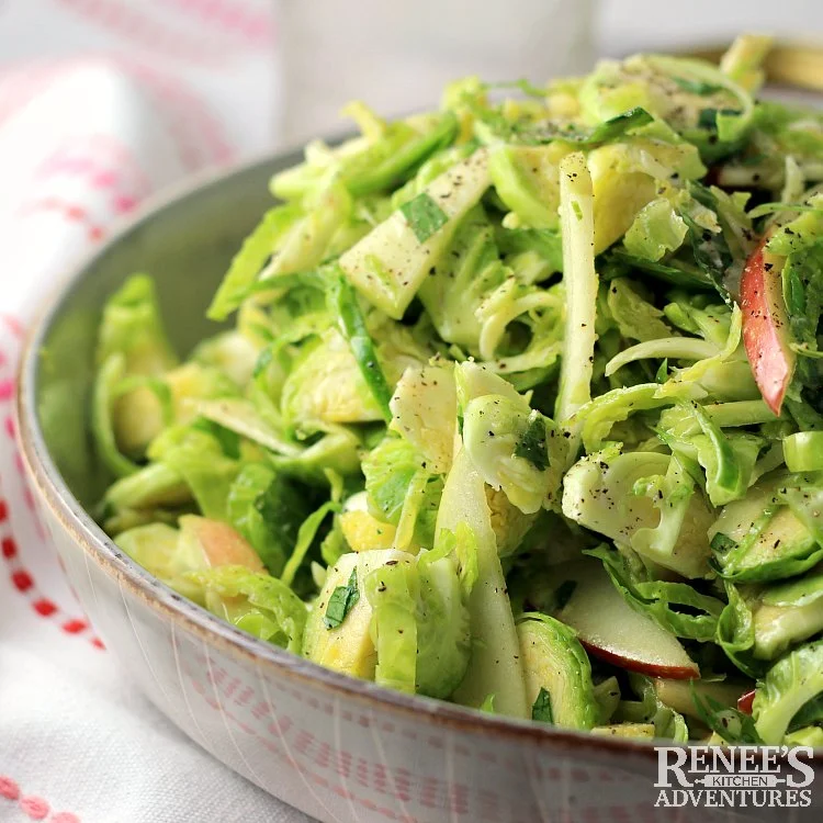 Shaved Brussels Sprouts Salad with Apples and Ginger in bowl ready to eat.