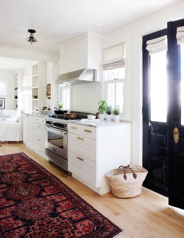 White Kitchen with An Oriental Rug Content in a Cottage