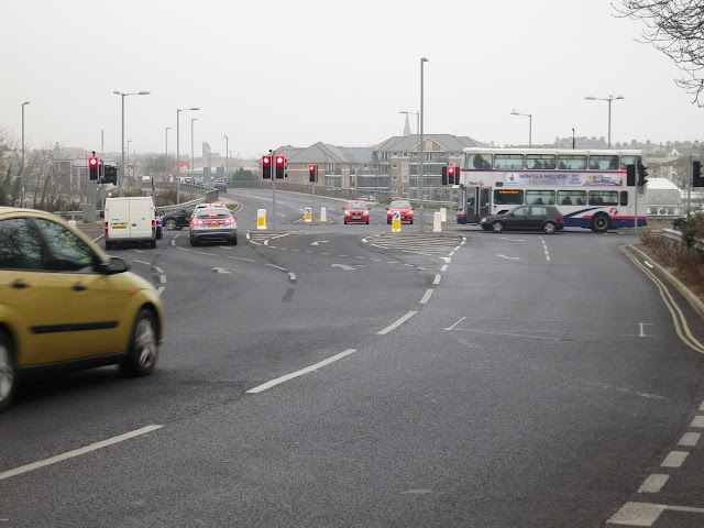 Busy intersection with lots of traffic lights and cars.