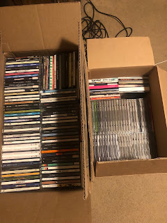 Two cardboard moving boxes full of CDs
