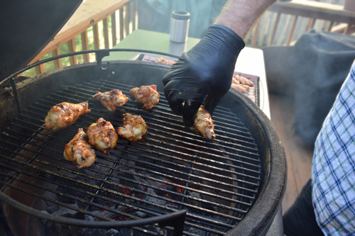 Grilling chicken wings on a big green egg kamado grill.