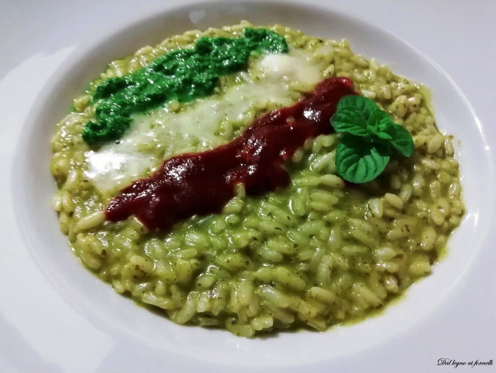 Risotto tricolore con pesto di rucola mantecato al taleggio.