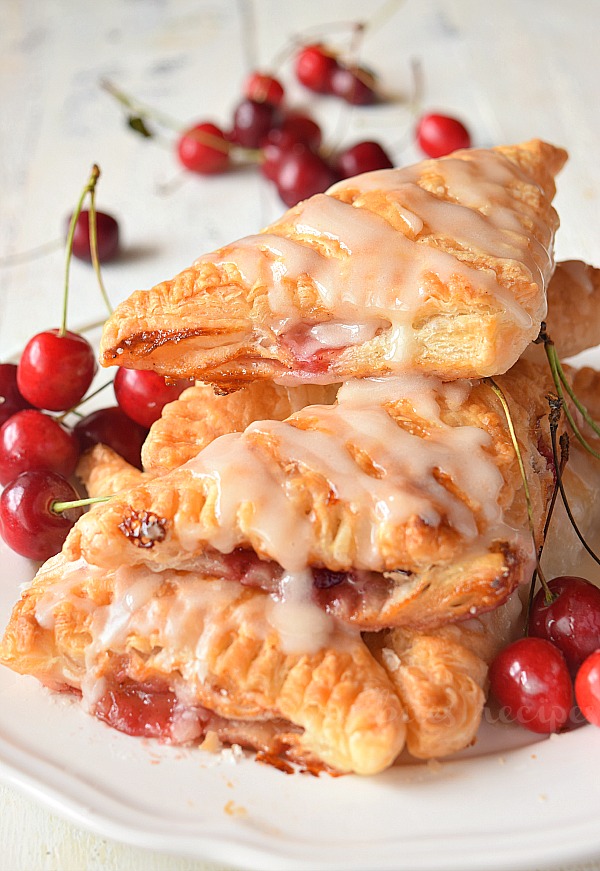 a plate with piled up cherry turnovers made with puff pastry