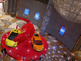 view from above of Lamborghinis and Tyrannosaurus sculpture display at City of Dreams Macau