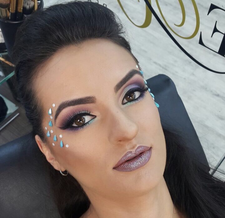 Maquiador profissional aplica maquiagem em uma modelo de menina bonita. o  rosto de uma garota de pele limpa. conceito de maquiagem e cosmetologia da  vida real. casamento, noite, maquiagem natural.