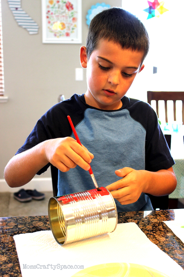 kid decorating recycled can for windsock kids craft 