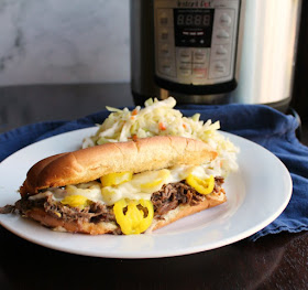 Big Italian beef flavor is possible in a fraction of the time with help from a pressure cooker. This is a dinner they'll request over and over. Plate of Italian beef sandwich an fresh coleslaw in front of instant pot
