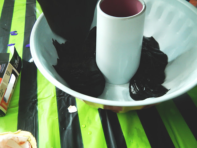 Black cake batter being poured into a cake tin
