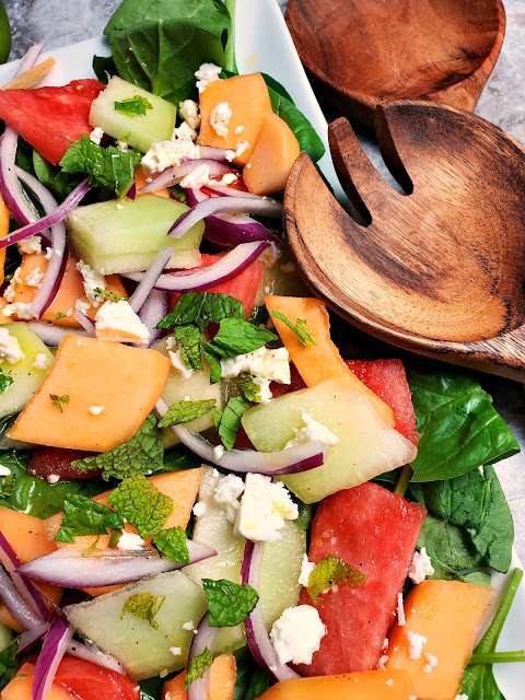 Refreshing Melon Salad:  Refreshingly cool and sweet melons mixed with onions and feta top a bed of baby spinach and doused with the most flavorful citrus garlic vinaigrette make one heck of a side dish! - Slice of Southern