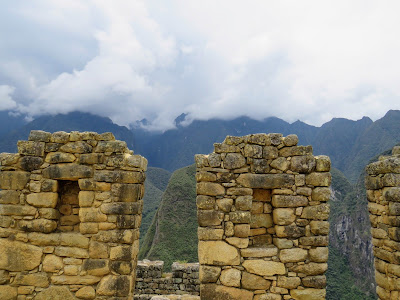 Pictures of Machu Picchu: Trapezoidal niches with low hanging clouds over the Andes at Machu Picchu