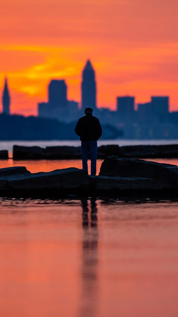 Silhouette image of man alone at sunset of the city